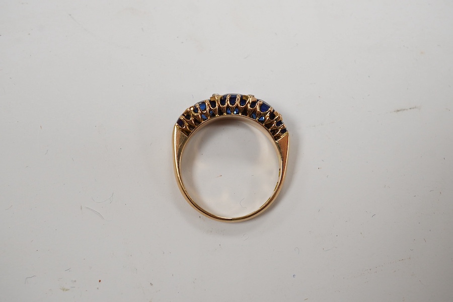 An 18ct and graduated five stone blue doublet set half hoop ring, with diamond chip spacers, size L, gross weight 3.3 grams. Condition - fair to good